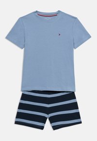 Ανοιχτό μπλε βαμβακερό μπλουζάκι με κοντά μανίκια και μικρό λογότυπο. Συνδυασμένο με σκούρο μπλε σορτς με οριζόντιες ανοιχτό μπλε ρίγες.