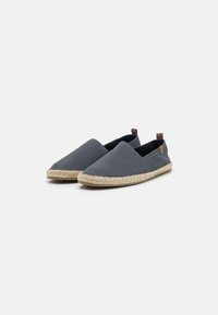 Grå kanvas espadrillos med en flettet jutesåle, minimalistisk design og to små brune skinnakcenter på hælen.