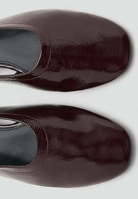Burgundy leather slip-on shoes with a glossy finish, rounded toe, and contrasting red stitching along the edges. Smooth inner lining.