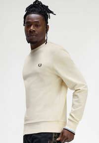 Felpa beige con collo rotondo, polsini a coste e logo ricamato sul petto. Realizzata in cotone, presenta una texture liscia.