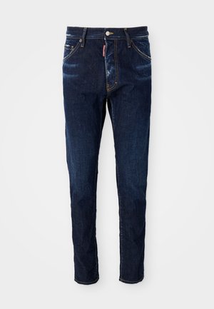 Dunkelblaue Slim-Fit-Jeans mit orangen Nähten, dezent verblassten Stellen, Fünf-Taschen-Design und einem kleinen roten Markentag an der vorderen rechten Tasche.