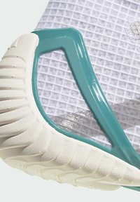 Bijela mrežasta gornja površina s teksturiranim rešetkastim uzorkom. Tirkizni plastični detalj i kremasta gumena potplata s izbočenim detaljima za bolju trakciju.