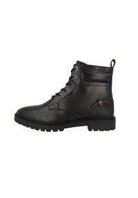 Botín de cuero negro hasta el tobillo con diseño de cordones, acentos texturizados y suela resistente. Presenta una pestaña en la parte posterior y una marca en la parte trasera.