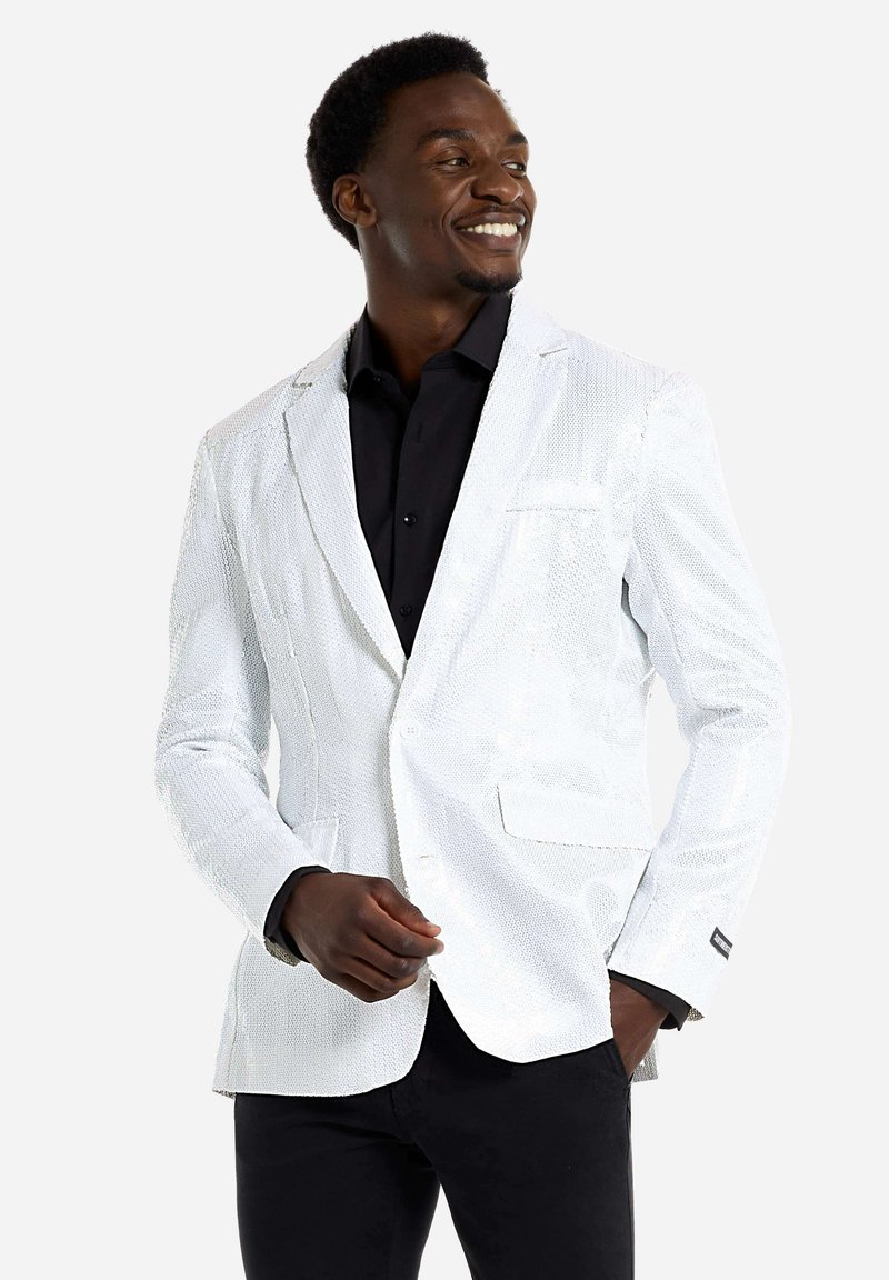Weißes Pailletten-Blazer mit Reverskragen, zwei Fronttaschen und einem einzelnen Knopfverschluss. Wird über einem schwarzen Hemd getragen, das eine glatte Textur aufweist.