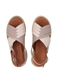 Strappy sandals in light pink and beige leather, featuring woven straps, a textured brown footbed, and a side buckle closure.