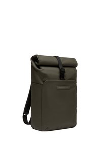 Sac à dos à rabat de couleur vert foncé, fabriqué en matière imperméable. Caractéristiques : une poche avant avec un détail réfléchissant fin et des bretelles réglables.