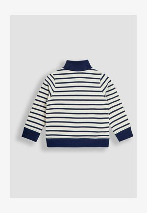 Pulover rayat în crem și bleumarin, cu guler înalt, maneci lungi, mansete cu dungi și o margine solidă bleumarin, realizat dintr-un material texturat.