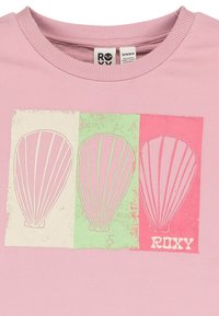 Sudadera de color rosa claro con un gráfico de tres globos aerostáticos en blanco, verde y rosa, con "ROXY" impreso en una fuente en negrita.