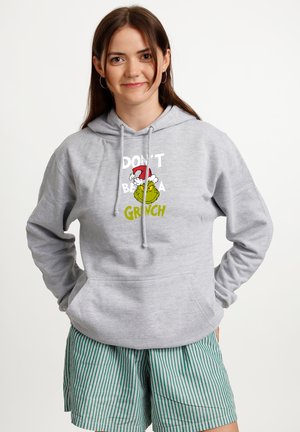 Gray hoodie with drawstrings, featuring colorful "Don't be a Grinch" graphic. Model pairs it with green-and-white striped shorts.