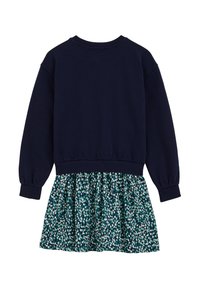 Mornarska sweatshirt majica s prilagojenimi manšeti, v kombinaciji z razširjeno obleko z cvetličnim vzorcem v odtenkih zelene, modre in bele.