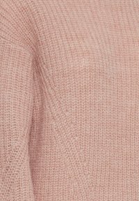 Maglione rosa con una finitura morbida e lavorata a maglia. Presenta una vestibilità ampia e un motivo di linee verticali creato dalla maglia.