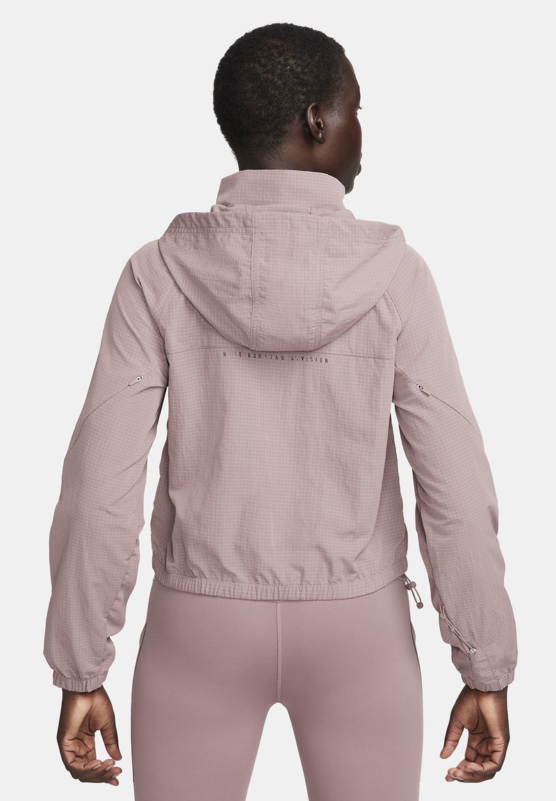 Lichtroze hoodiejack gemaakt van textuurstof, met elastische manchetten, een trekkoordzoom en zijzakken met ritsen.