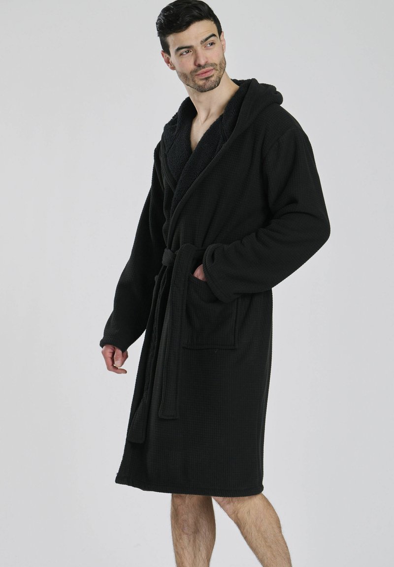 Zwarte textuur badjas met een capuchon, lange mouwen en zakken. Veters om de taille, met een zachte binnenvoering voor comfort.