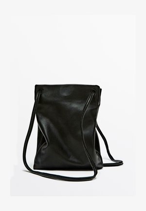 Borsa a sacco in pelle nera con texture liscia, silhouette morbida e due lunghe tracolle. Design minimalista, senza hardware visibile o motivi.