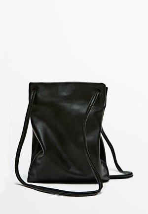 Borsa a sacco in pelle nera con texture liscia, silhouette morbida e due lunghe tracolle. Design minimalista, senza hardware visibile o motivi.