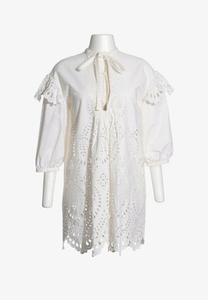 Robe blanche en coton avec broderie ajourée, manches ballon trois-quarts avec découpes en dentelle et fermeture par lien au niveau du col rond.