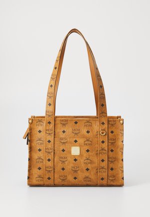 Sac fourre-tout synthétique beige avec logos noirs en relief, motifs en diamant, doubles anses et accents en métal doré.