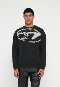 Sweatshirt preta com um grande design gr�áfico branco desbotado no peito. Apresenta punhos canelados e decote redondo, feito de tecido macio.