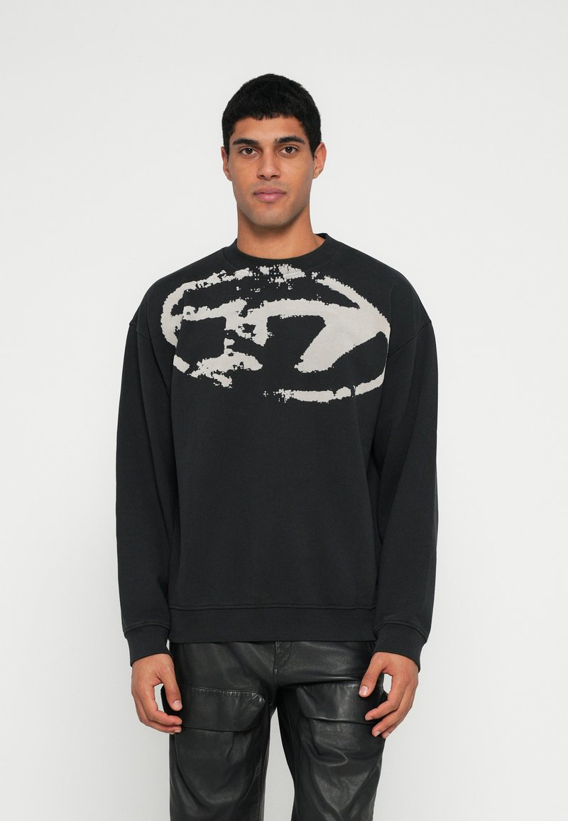 Sweatshirt preta com um grande design gráfico branco desbotado no peito. Apresenta punhos canelados e decote redondo, feito de tecido macio.