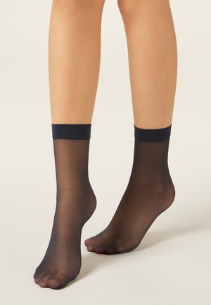 Gennemsigtige sorte ankelstrømper med en mørk elastisk kant, glat tekstur og åben tæe-design, der giver et let udseende for komfort.