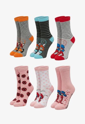 Six paires de chaussettes colorées pour enfants arborant des personnages et motifs, notamment des renards, des chats et des coccinelles, dans diverses combinaisons de couleurs.