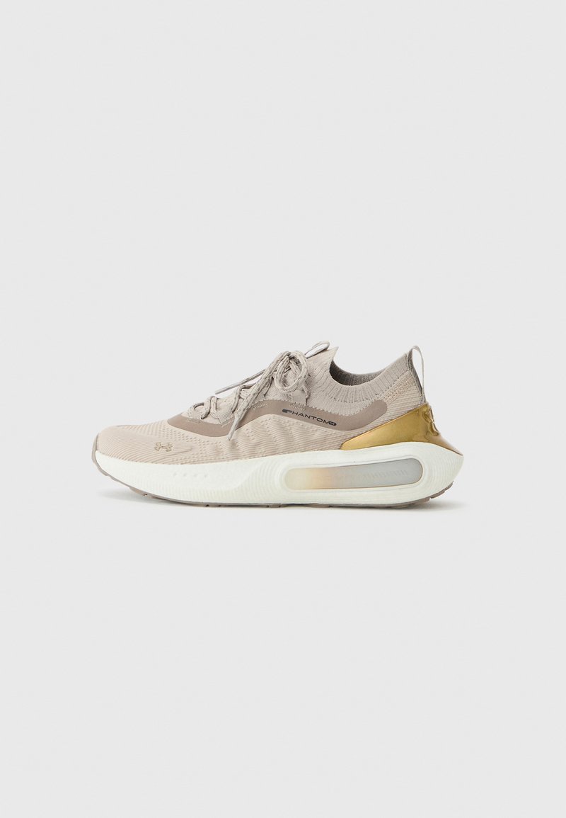 Beige athletic shoe with a knit upper, gold accent on the heel, and white sole featuring a visible air cushioning unit.