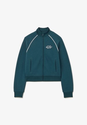 Sudadera con cremallera en color verde azulado, con ribetes blancos, cuello alto y bolsillos delanteros. Presenta texto bordado: "PARÍS 1996 Rue de Rivoli Sport Club."