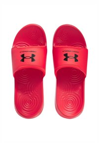 Chanclas rojas de material sintético texturizado. Presentan una cinta ancha con el logo negro de Under Armour. Patrones circulares en la plantilla.