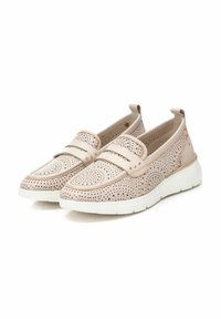 Mocasines de color beige claro con diseño perforado, estilo deslizante acolchado, parte superior de cuero suave y suela de goma blanca. Presenta correas dobles y tachuelas.