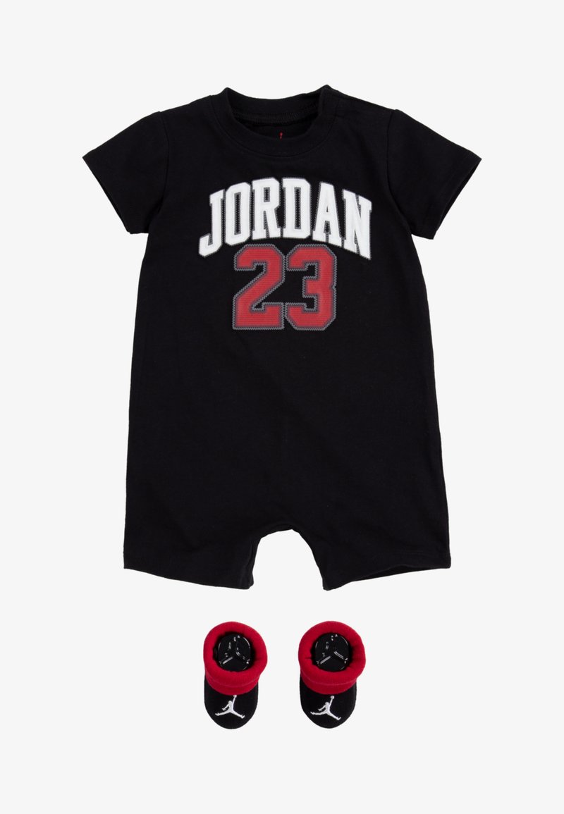 Mono de algodón negro con la palabra "JORDAN" y el número "23" en letras blancas y rojas. Incluye botines negros con acentos rojos a juego. Mangas cortas, cierre a presión.