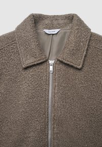 Giacca marrone testurizzata con chiusura a zip e colletto. La fodera interna è liscia. L'etichetta riporta "CALLIOPE." Il materiale sembra morbido e soffice.