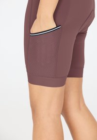 Bordåtsfärgade idrottsshorts med en meshficka, med en figurnära design, slät textur och en kontrasterande kant längs fickans kant.