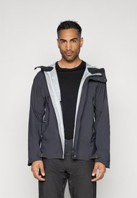 Tvirtas vandeniui atsparus švarkas tamsiai mėlynos spalvos su šviesiai pilku interjeru. Į komplektą įeina nuimamas kapišonas, priekinių kišenių ir reguliuojami užsegimai.