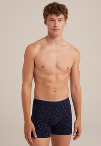 Tengerész kék boxer alsónemű, sokszínű pöttyökkel, puha anyagból készült, testhez álló kialakítással és kényelmes, rugalmas derékkal.