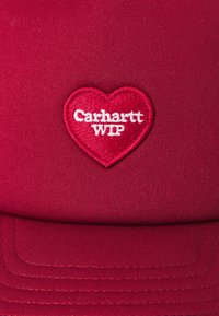 Rode pet van stof met een hartvormige geborduurde patch met "Carhartt WIP" in het wit. Schild met gestikte accenten.