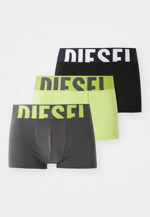 Tres pares de calzoncillos ajustados para hombre: negros, gris oscuro y verde neón, cada uno con una banda ancha que presenta el logo "DIESEL" en colores contrastantes.