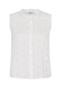 White sleeveless blouse featuring a textured embroidered pattern with circular motifs and a ruffled neckline, secured by front buttons.