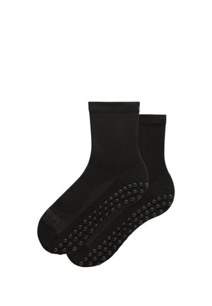 Par sorte ankelstrømper med skridsikre gummigreb under sålerne for bedre greb og sikkerhed.