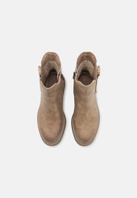 Beige enkellaarsjes met een glad leren buitenkant, ronde neus en ritsluiting aan de zijkant. Zacht binnenwerk en gestikte accenten.
