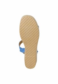 Sandale en suedine bleue avec une semelle en caoutchouc beige. La semelle présente un motif en losange pour une meilleure adhérence. La partie supérieure a un design minimaliste avec une seule sangle.