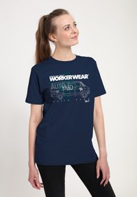 Camiseta azul marino de algodón, con un estampado gráfico de una furgoneta y el texto "ROPA DE TRABAJO" en blanco y verde. Mangas cortas.