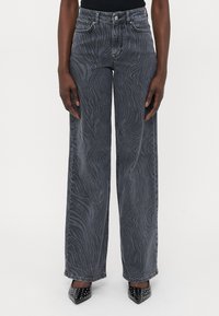 Široke jeans hlače iz temno sive denima, ki imajo subtilen vzorec zebre, pet žepov in kovinsko zaponko.