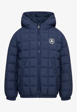 Chaqueta acolchada azul marino con capucha, cremallera frontal, bolsillos laterales, puños elásticos y un logo circular de Converse All Star en el pecho.