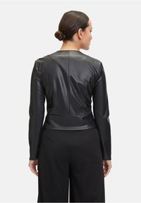 Czarna skórzana kurtka o dopasowanym kroju, z długimi rękawami i gładką fakturą. Posiada minimalistyczny detal w postaci szwu z tyłu.