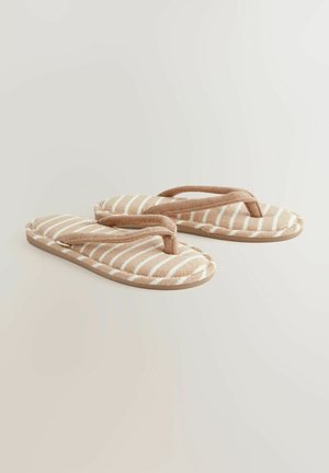 Gestreifte beige Hausschuhe mit einem weichen Obermaterial und kontrastierenden weißen Streifen. Flip-Flop-Design mit gepolstertem Riemen und strukturiertem Sohlen.