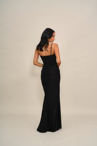 Μαύρο, εφαρμοστό φόρεμα με λεπτές τιράντες, σχέδιο με ρεβρέ στην πλάτη, που ανοίγει ελαφρώς στο τελείωμα, κατασκευασμένο από υφή υφάσματος με διακριτική λάμψη.