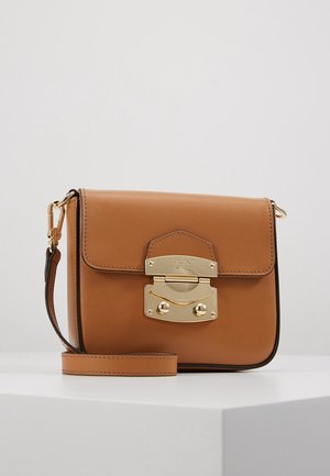 Ruskea nahkainen olkalaukku, jossa on kullanvärinen lukko ja irrotettava hihna, esillä valkoisella pinnalla yksinkertaisen taustan edessä.