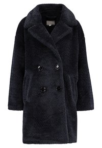 Abrigo de doble botonadura en azul marino oscuro, con una tela suave y texturizada. Presenta grandes botones negros, bolsillos laterales y un cuello con muesca.