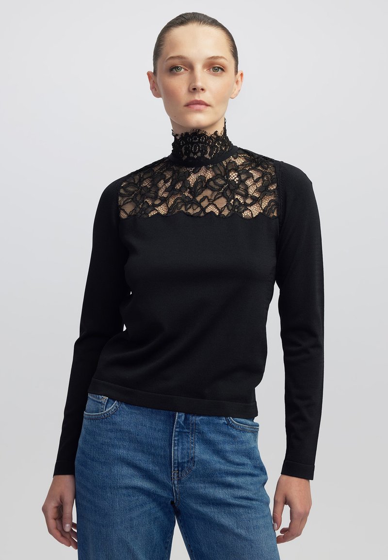 Zwarte lange mouwen top met een hoge kant kraag en bloemen kant details aan de voorkant. De trui heeft een aansluitend ontwerp en een soepele textuur.