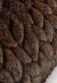Brun faux fur-stof med et struktureret, flettet mønster. Blødt, tæt tekstur med varierende længder af fibre, som skaber dybde og visuel interesse.